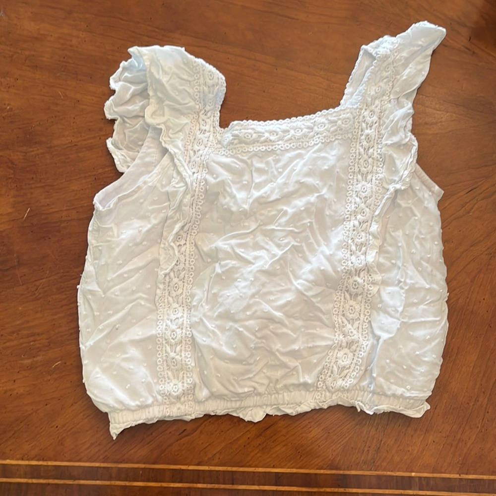 White kids top with flowers and other designs. Wide tank straps.